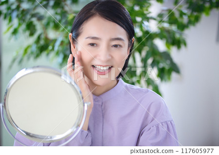 中年婦女在客廳做皮膚護理 中年婦女在客廳做皮膚護理 117605977