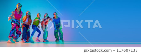 Dancers posing, showing their individuality throw moves in neon light against gradient background with negative space to insert text. Dancers posing, showing their individuality throw moves in neon light against gradient background with negative space to insert text. 117607135