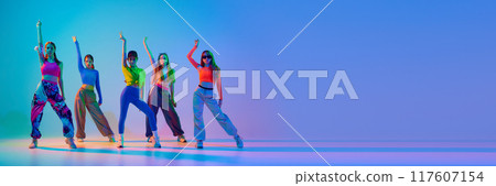 Banner. Teenage girls dancing hip-hop in neon light against gradient studio background with negative space to insert text. 117607154