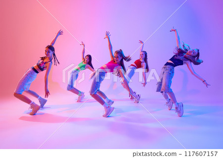 With grace and intensity, dancers bring their choreography to life on stage in neon light against gradient pink background. With grace and intensity, dancers bring their choreography to life on stage in neon light against gradient pink background. 117607157