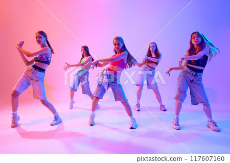 Group's unity shines through in this electric performance, where every move tells story in neon light against gradient pink background. 117607160
