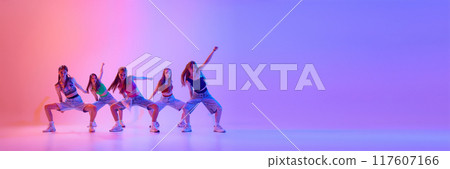 Banner. Group of young girls dancing in neon light against gradient pink background with negative space to insert text. 117607166