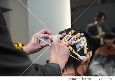 Hairdresser who winds a perm rod Hairdresser who winds a perm rod 117608265