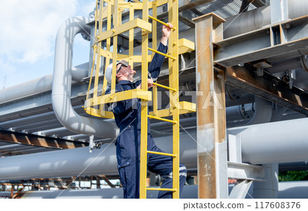 Factory engineer or technician worker climb up on stair of petrochemical gas pipeline to work or maintenance in workplace. Factory engineer or technician worker climb up on stair of petrochemical gas pipeline to work or maintenance in workplace. 117608376