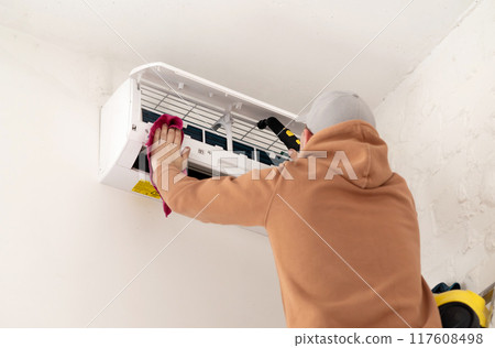 Technician service using vacuum cleaner to cleaning the air conditioner. Electrician repairing 117608498