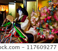 A traditional Kyoto Hina doll surrounded by a gold folding screen and peach blossoms 117609277