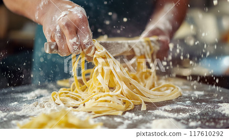 Hand-cutting fresh pasta noodles. 117610292