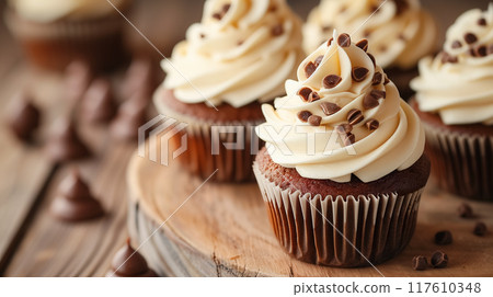 Delicious cupcakes topped with cream and chocolate. Delicious cupcakes topped with cream and chocolate. 117610348