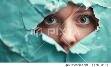 Eyes peering through a torn turquoise paper. Eyes peering through a torn turquoise paper. 117610381