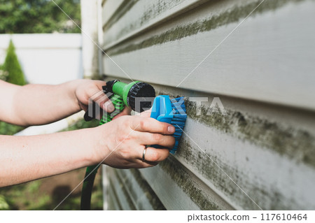 Cleaning algae and mold from vinyl siding of house with pressure spray jet Cleaning algae and mold from vinyl siding of house with pressure spray jet 117610464
