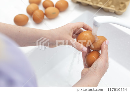 Washing chicken eggs under water Washing chicken eggs under water 117610534