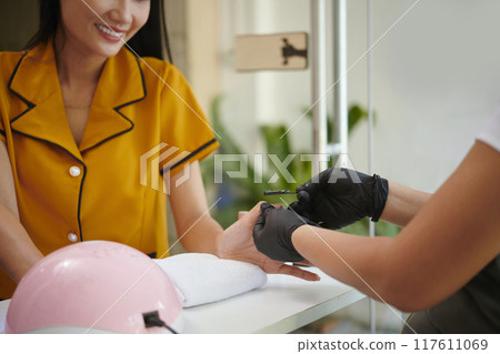 Receiving Manicure at Nail Salon with Professional Care Receiving Manicure at Nail Salon with Professional Care 117611069