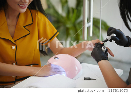Manicuring Nails with Professional Equipment in Salon Manicuring Nails with Professional Equipment in Salon 117611073