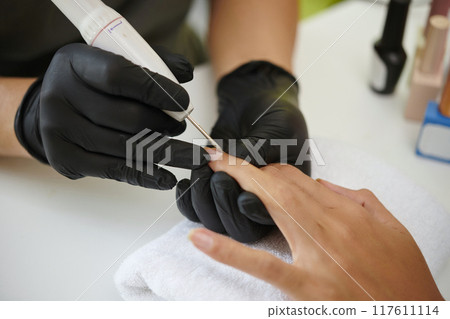 Conducting Manicure Procedure with Electric Nail File 117611114