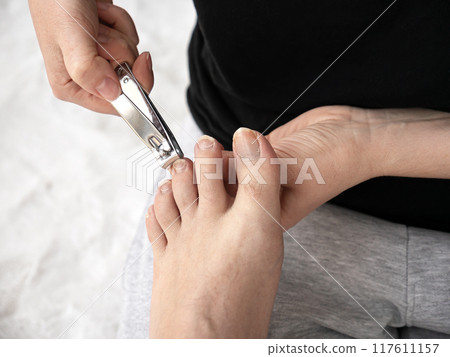 Cut long nails on male foot. Making pedicure procedure Cut long nails on male foot. Making pedicure procedure 117611157