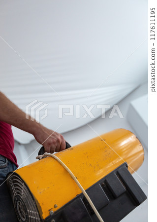 Installs a stretch ceiling 117611195