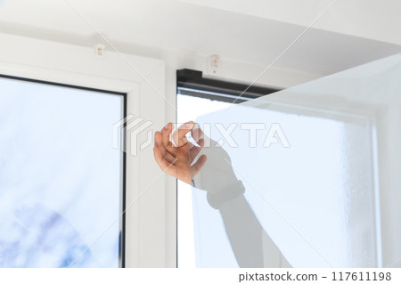 Installation of tinted film. Ultraviolet and energy afficiency concept. Installation of tinted film. Ultraviolet and energy afficiency concept. 117611198