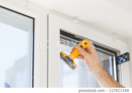 Installation of tinted film. Ultraviolet and energy afficiency concept. Installation of tinted film. Ultraviolet and energy afficiency concept. 117611199