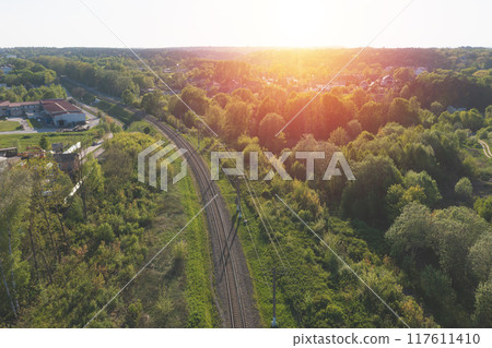 Railway through summer forest. Aerial view. Sunset time Railway through summer forest. Aerial view. Sunset time 117611410