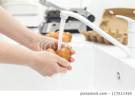 Washing chicken eggs under water Washing chicken eggs under water 117611489
