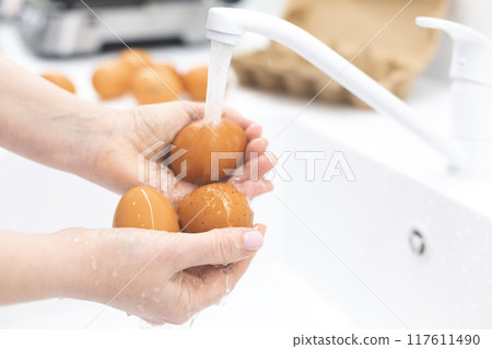 Washing chicken eggs under water Washing chicken eggs under water 117611490