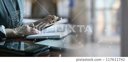 Businesswoman analyzes a document in front of a network. 117611742