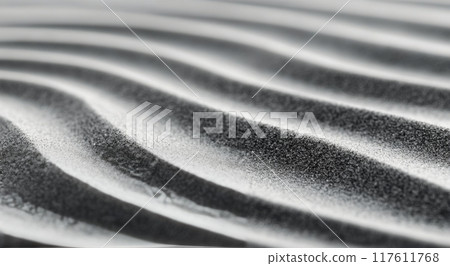 Close-up of textured black sand with fine shimmering grains in soft wave patterns 117611768