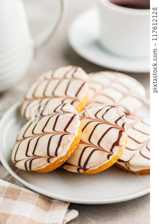 Sweet dessert with sugar coating on plate on kitchen table. 117612128