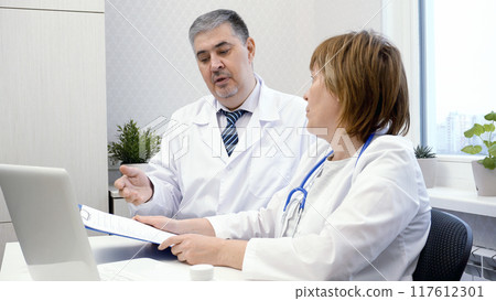 Male Doctor Mentoring Female Doctor at Workplace 117612301