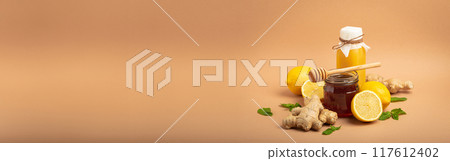 Composition with detox drink, sea buckthorn berries, lemons, mint, ginger, honey in glass jar. Food for immunity stimulation and against flu. Healthy natural remedies to boost immune system 117612402