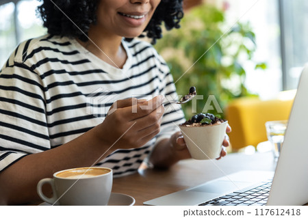 Woman in striped blouse enjoying delicious tiramisu 117612418