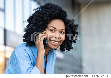 Portrait picture of a smiling woman talking on the phone 117612421