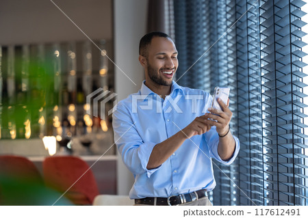 Businessman having online video communication in cafe while having break Businessman having online video communication in cafe while having break 117612491