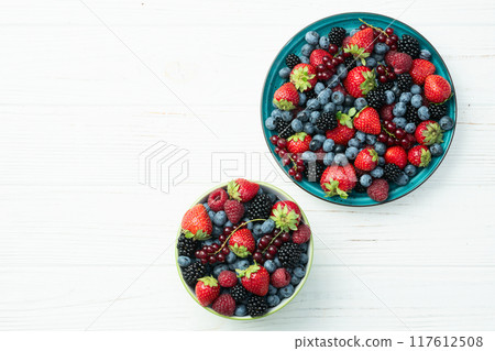Mix of ripe colorful berries in bowl photography . Blueberry , strawberry , raspberry , blackberry and red currant . Top view Mix of ripe colorful berries in bowl photography . Blueberry , strawberry , raspberry , blackberry and red currant . Top view 117612508