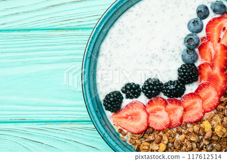 Healthy breakfast . Yogurt with berries ( strawberry , raspberry , blueberry , blackberry ) , granola and chia seeds . Top view 117612514