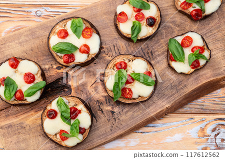 Italian mini pizza . Aubergine (eggplant ) with mozzarella cheese and basil . On rustic background 117612562
