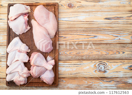 Raw mixed chicken meat parts for cooking on rustic background Raw mixed chicken meat parts for cooking on rustic background 117612563