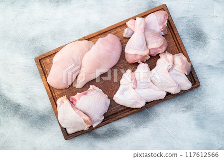 Raw mixed chicken meat parts for cooking on rustic background Raw mixed chicken meat parts for cooking on rustic background 117612566