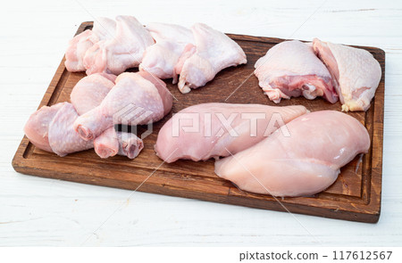 Raw mixed chicken meat parts for cooking on rustic background Raw mixed chicken meat parts for cooking on rustic background 117612567