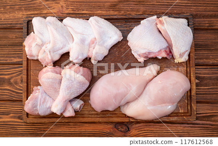 Raw mixed chicken meat parts for cooking on rustic background Raw mixed chicken meat parts for cooking on rustic background 117612568