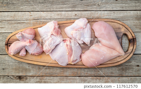Raw mixed chicken meat parts for cooking on rustic background Raw mixed chicken meat parts for cooking on rustic background 117612570