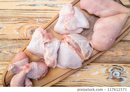 Raw mixed chicken meat parts for cooking on rustic background Raw mixed chicken meat parts for cooking on rustic background 117612571