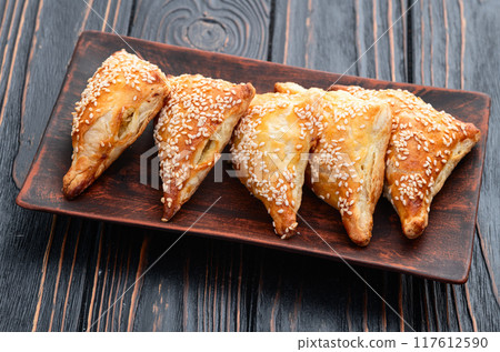 Homemade triangle puff pastry with meat on rustic background . Samosa Homemade triangle puff pastry with meat on rustic background . Samosa 117612590