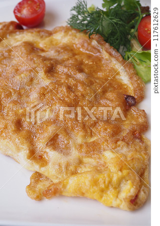 Plain Egg Omelette and fresh cherry tomato on a plate  117612629