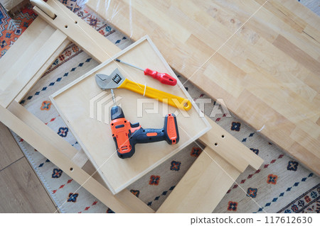 An electric screwdriver is on the floor,  117612630
