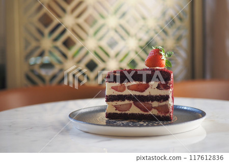 Indulge in a Delicious Red Velvet Cake adorned with Fresh Strawberries and Cream Cheese Frosting Indulge in a Delicious Red Velvet Cake adorned with Fresh Strawberries and Cream Cheese Frosting 117612836