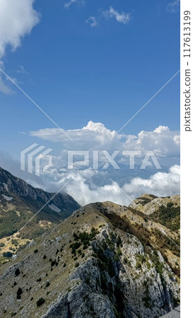 Mountain peaks surrounded by clouds 117613199