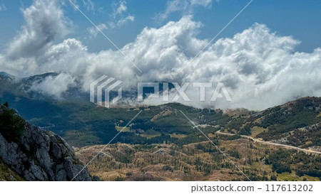 Low clouds rolling over green valleys 117613202