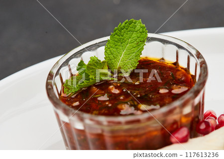 Spicy dipping sauce with fresh mint garnish, perfect for enhancing grilled dishes and appetizers Spicy dipping sauce with fresh mint garnish, perfect for enhancing grilled dishes and appetizers 117613236