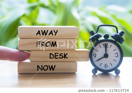 Away from desk now text on wooden blocks with alarm clock. Out of office concept 117613724